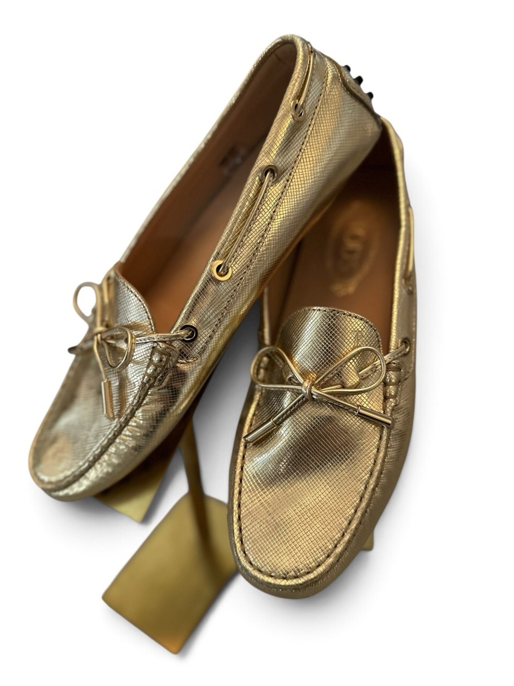 Tod’s Metallic gold gommini leather driving shoes.
